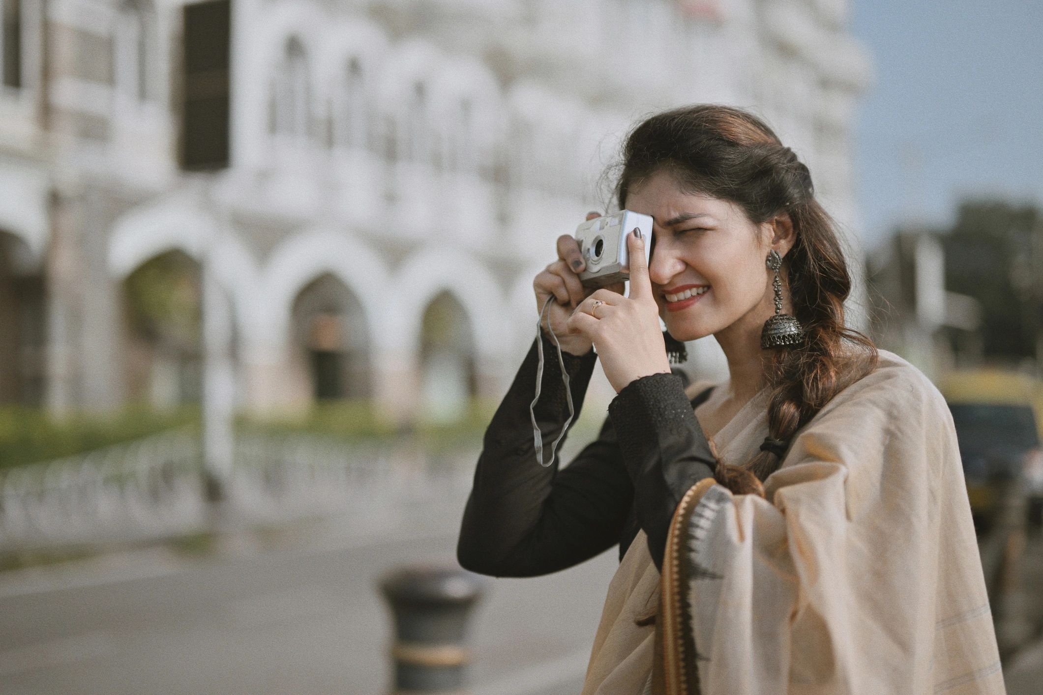 Mumbai journalist using a camera on a city street